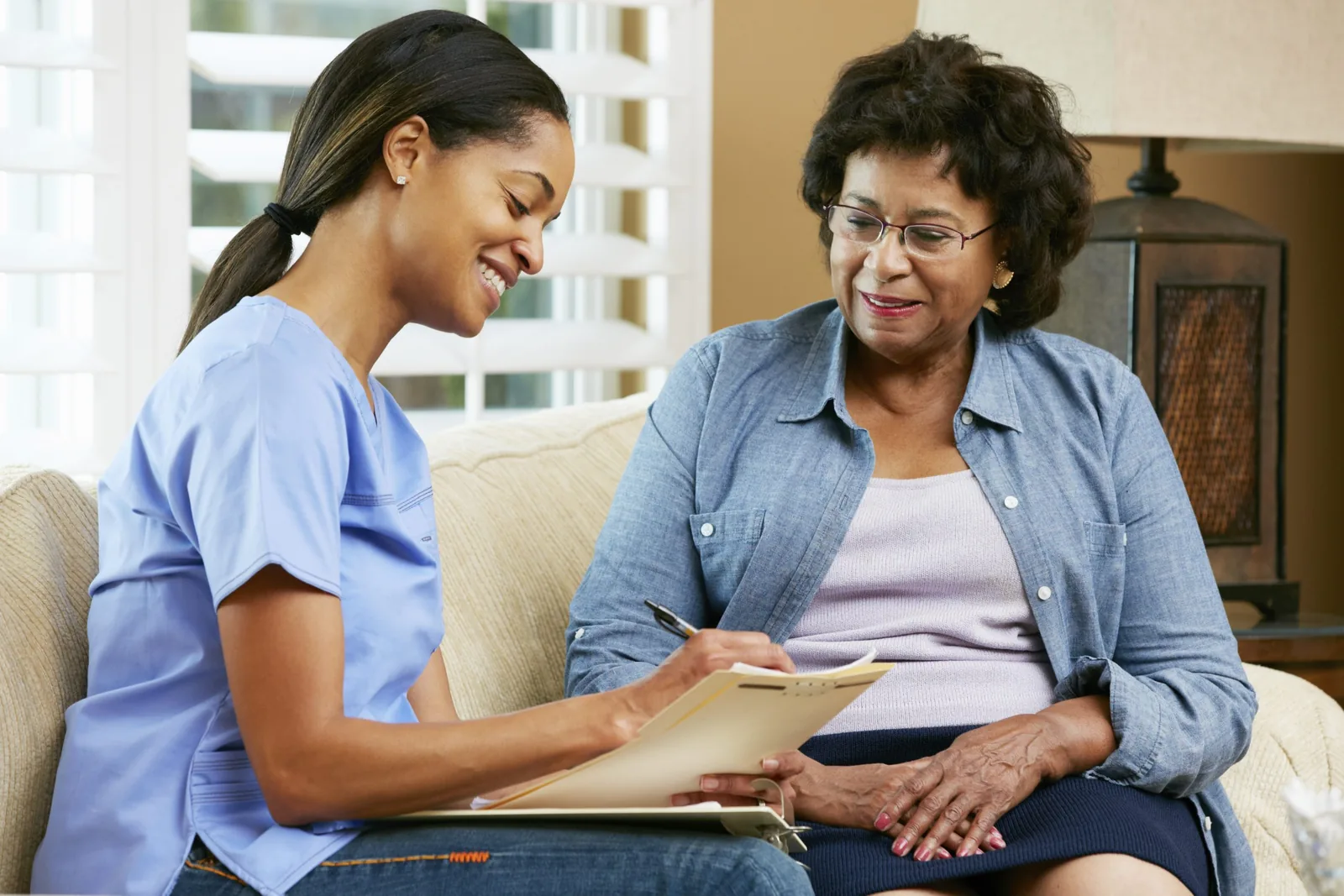Carer and client talking together on a sofa
