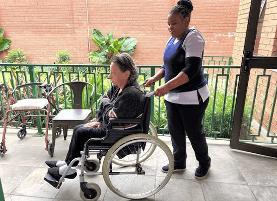 A Caring Hearts carer with a client on a veranda