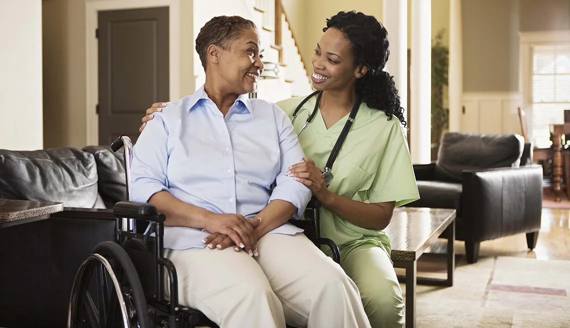 A caregiver with a client in a wheelchair at home
